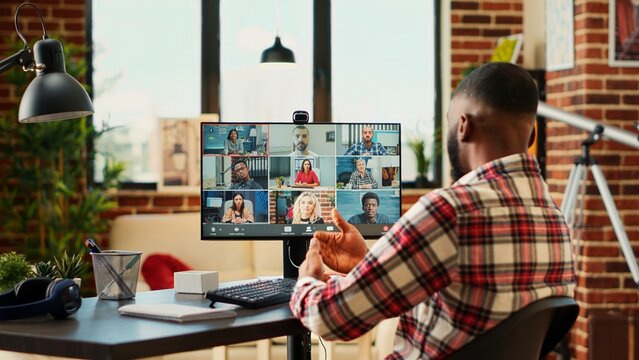 Teleworking Employee In Cozy Apartment Personal Office Discussing With Coworkers During Video Conference Meeting. Executive Holding Online Video Call With Remotely Working Diverse International Team