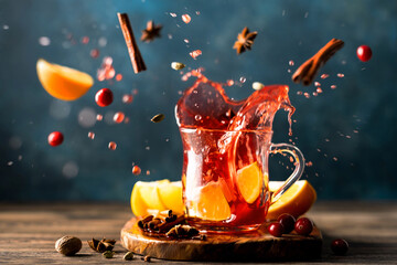 A splash of hot mulled wine with oranges, cranberries and spices in a glass. A traditional warming drink for the autumn-winter season. Stock image - 659189480