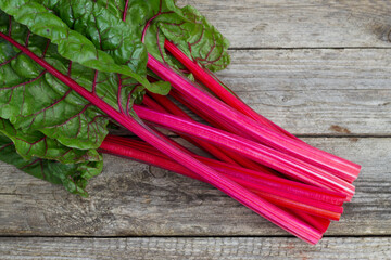 bunch of fresh red chard stems on the wooden background