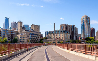 Minneapolis downtown skyline viewing from the Stone Arch Bridge under a sunny day