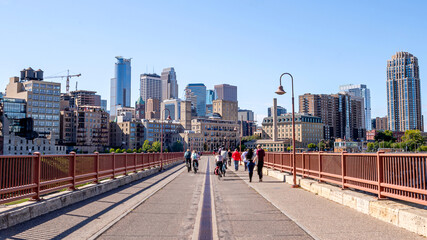 Minneapolis downtown skyline viewing from the Stone Arch Bridge under a sunny day	