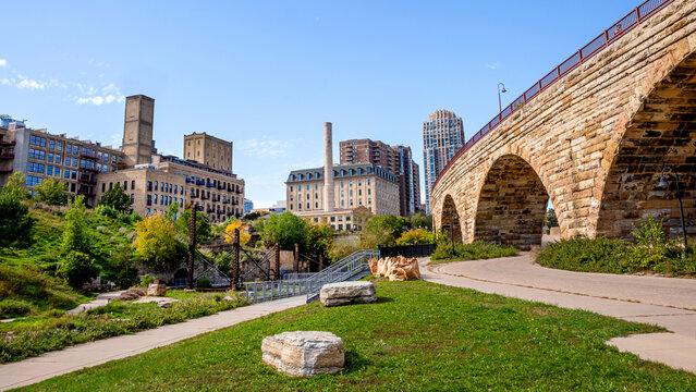 Minneapolis downtown skyline viewing besides Stone Arch Bridge under a sunny day