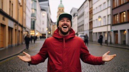 Man in a red hoodie, standing in a city, arms wide open, expressing joy.