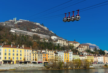 Fototapeta premium Image of cable cars in Grenoble in autumn over riverside, France.