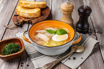 hearty noodle soup with chicken, healthy, nutritious on a wooden table