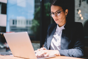 Fototapeta premium Female entrepreneur using laptop in street cafe