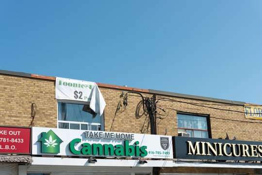 exterior building facade and sign of Take Me Home Cannabis (TMH Cannabis), located at 3257 Dufferin Street, Toronto, Ontario on a blue sky