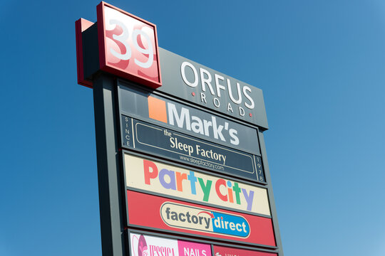 exterior pylon sign listing businesses located at 39 Orfus Road, Toronto, Ontario isolated on a blue sky