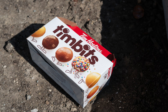 discarded cardboard box that once contained Timbits, bite-sized doughnut holes on the ground