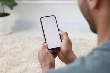 Man using modern mobile phone indoors, closeup