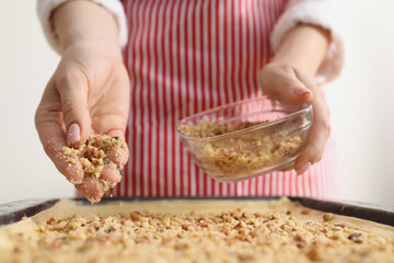 Making delicious baklava. Woman adding chopped nuts to dough, closeup