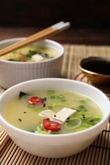 Bowls of delicious miso soup with tofu served on table, closeup