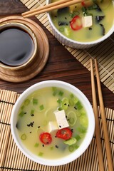 Bowls of delicious miso soup with tofu served on table, flat lay