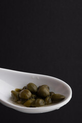 Traditional appetizer caper in a spoon. Copy space.