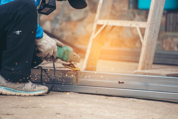 Construction Worker hands using Welding machinery iron metal sparking. Men hands wear protective glove Hot flame metal work cutting fire iron workshop. Locksmith use Welding machine cut metal process