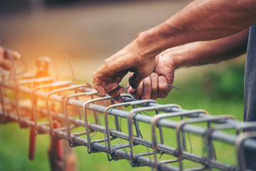 Construction Men hands bending cutting steel wire fences bar reinforcement of concrete work. Worker hands using pincer pliers iron wire. Outdoor Worker using wire bending pliers, construction work - obrazy, fototapety, plakaty