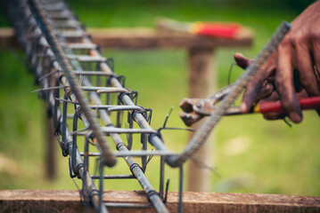 Construction Men hands bending cutting steel wire fences bar reinforcement of concrete work. Worker...