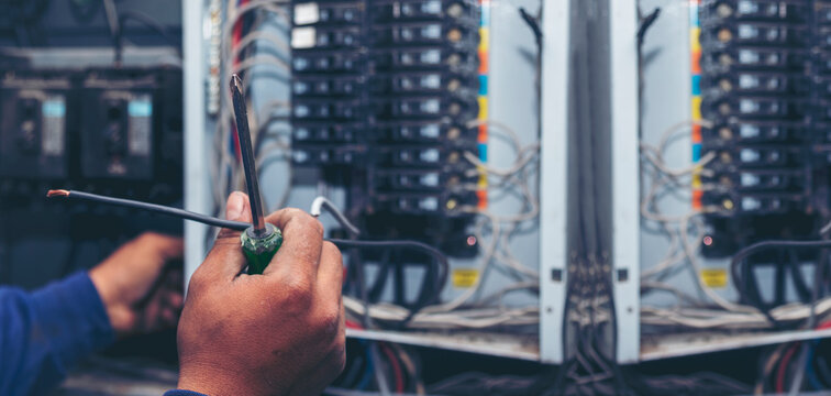 Inspector men hands working switchboard machinery maintenance service. Electrical mechanic technician check wire electric cabinet.  Electrician circuit repair voltage operation. Men hands fix breaker