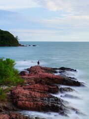 Portrait of tourists standing on rocks at Lan Hin Pink National Park, Chanthaburi Province, Thailand.
