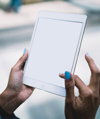 Faceless woman browsing tablet in city