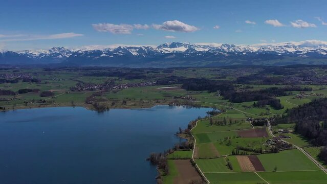 Drone shot, drone photo, drone flight from Lake Greifen with a view of the snow-covered mountain peaks of the Alps, Maur, Canton Zurich, Switzerland, Europe