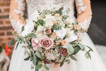 bride holding her wedding beautiful pink and white bouquet of fresh and faux flowers
