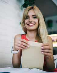 Cheerful young businesswoman receiving letter in office