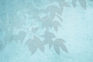 Blurred shadow from leaves plants on the blue concrete wall. Transparent blurry shadow of tropical natural leaves sunlight. Minimal abstract background for product presentation. Spring and summer.