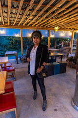 Mujer afro con gorra y estilo entre luces llegando la noche