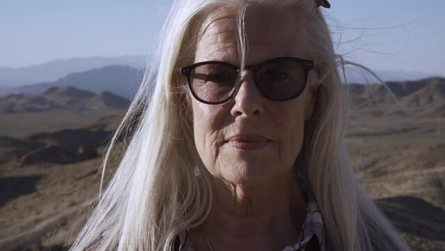 Portrait blond woman with sunglasses is smiling. She is happy and rest in deserts. 