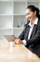 Happy businesswoman using tablet at cafe.