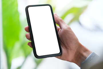 Close up view woman holding mobile phone at workspace. Blank screen for your advertise design.