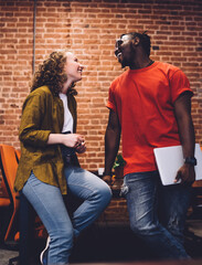 Laughing young friends chatting in class room