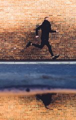 Fototapeta na wymiar Sportive male running on sidewalk