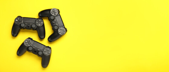 Modern controllers on yellow background with space for text © Pixel-Shot