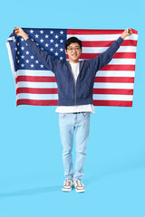 Young Asian man with USA flag on blue background