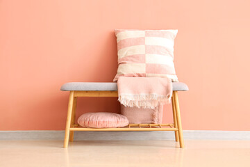 Grey bench with cushions and blanket near pink wall - Powered by Adobe