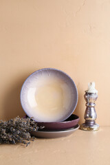 Vintage tableware, candle holder and lavender on beige table