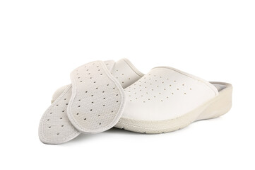 Pair of slippers and orthopedic insoles on white background