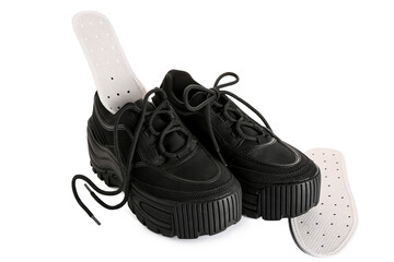 Pair of stylish black shoes with orthopedic insoles on white background