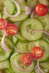 close-up of marinated sliced cucumber tomato and onion salad, simple and delicious fresh vegetarian summer side dish, taken straight from above in full flame, food background
