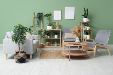 Interior of modern living room with grey sofa, armchairs, coffee table and houseplants
