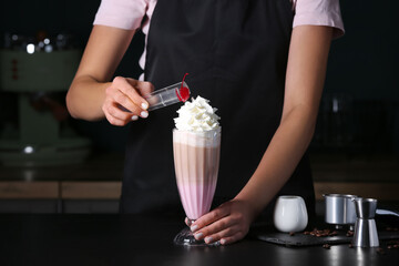 Barista making tasty latte with whipped cream in cafe