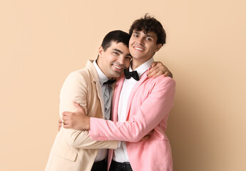 Married gay couple hugging on beige background
