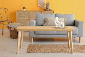 Wooden coffee table with decor in interior of living room
