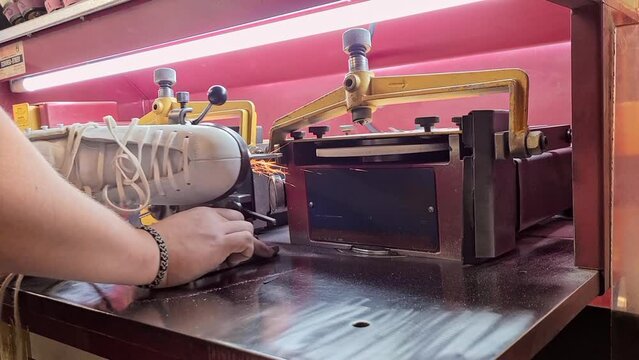 Side view of sharpening a figure skate and flying sparks.