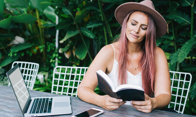 Fototapeta premium Focused woman reading book in park