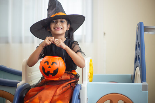 Happy Asian child girl in a witch costume to Halloween. trick or treat. Kids trick or treating.
