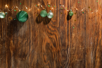 Christmas lights and baubles on brown wooden background