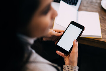 Lady texting on cellphone sitting at table